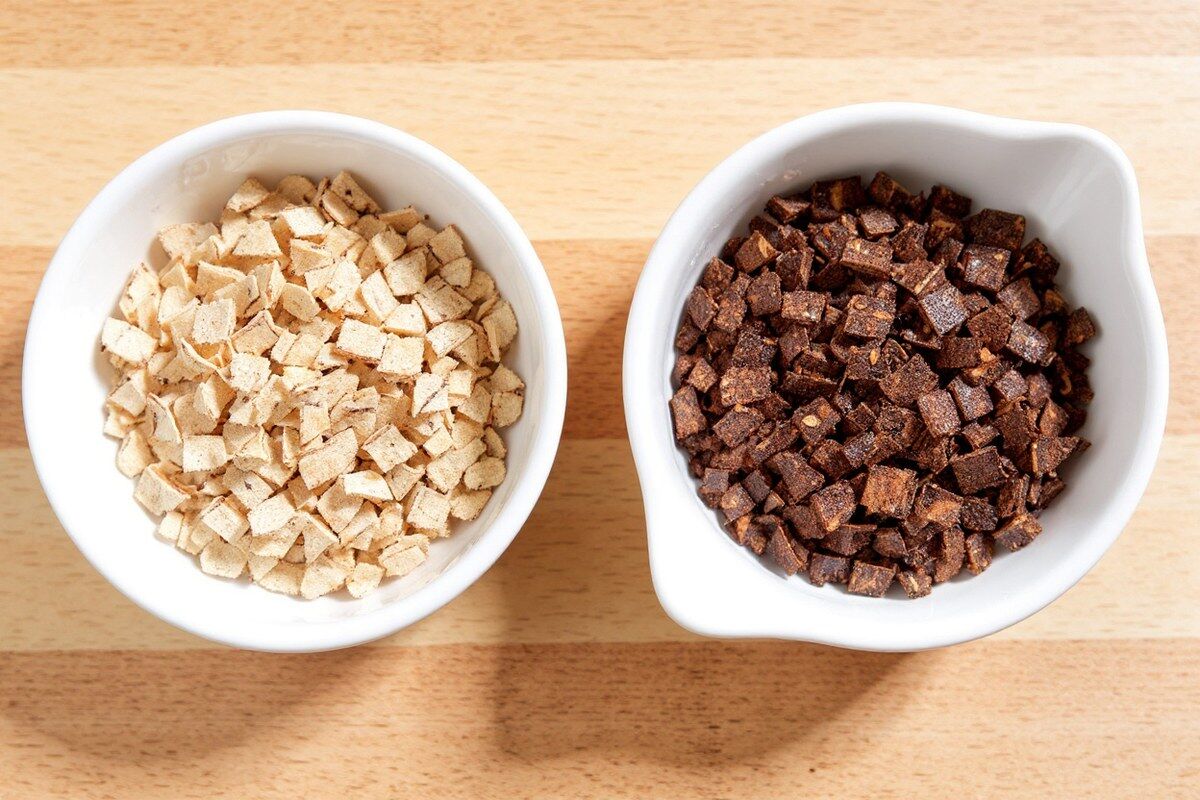 Raw and roasted dandelion root pieces in two small dishes